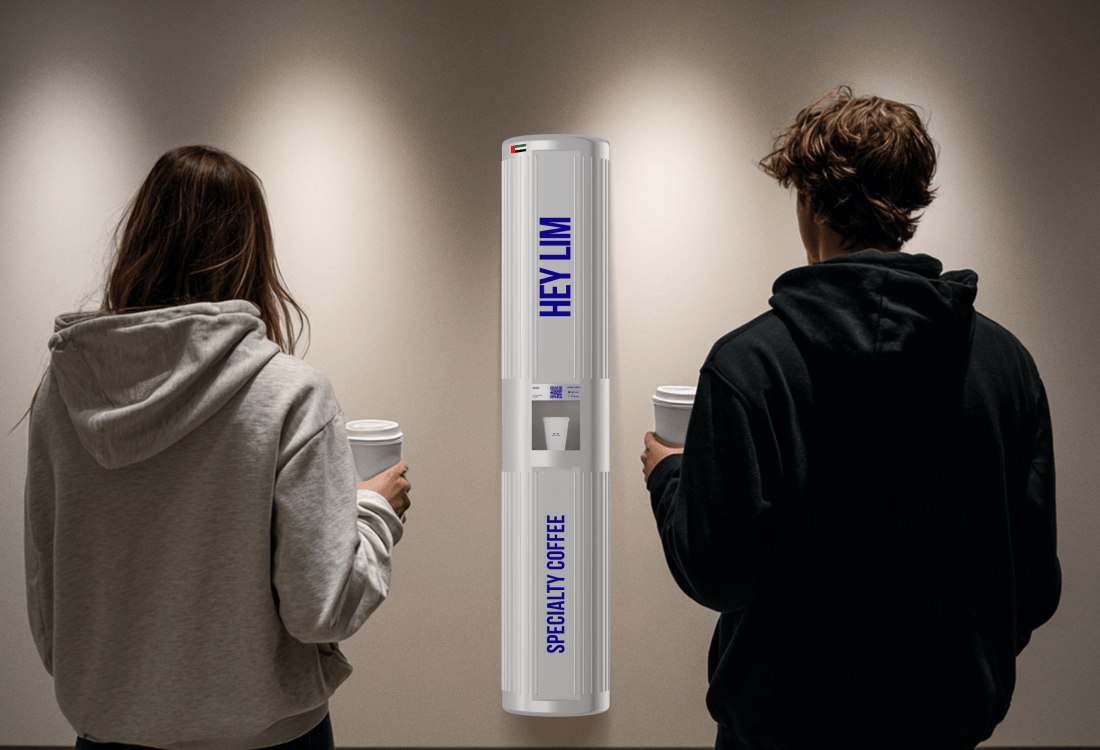 Two customers enjoying specialty coffee from HEYLIM autonomous coffee machine in modern gallery space